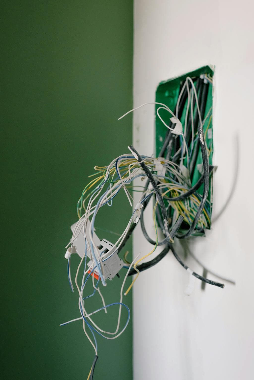 Upstate SC electrical repair in progress Opened power socket with various wires on white wall during repair at home